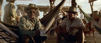 A group of men sitting next to each other on a hammock