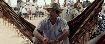A man sitting on a hammock in front of a group of people