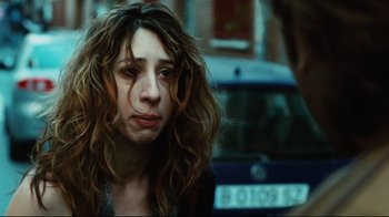 Movie still from “Biutiful” (2010), directed by Alejandro G. Iñárritu – A woman with long brown hair is looking at the camera; Close Up shot, Over the shoulder angle