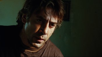 Movie still from “Biutiful” (2010), directed by Alejandro G. Iñárritu – A person wearing a brown t - shirt; Close Up shot, Over the shoulder angle