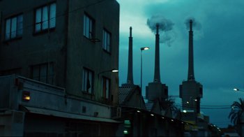 Movie still from “Biutiful” (2010), directed by Alejandro G. Iñárritu – Smoke billows out of the chimneys of an industrial plant; Extreme Wide shot, Low angle