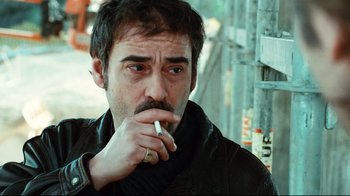 Movie still from “Biutiful” (2010), directed by Alejandro G. Iñárritu – A person holding a cigarette in his mouth; Close Up shot, Over the shoulder angle