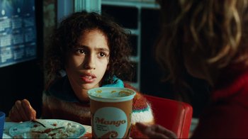 Movie still from “Biutiful” (2010), directed by Alejandro G. Iñárritu – A woman sitting at a table with a cup of coffee; Close Up shot, Over the shoulder angle
