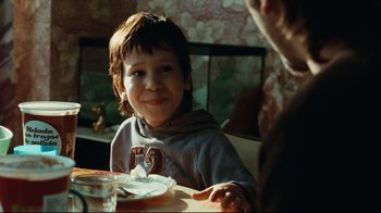 Movie still from “Biutiful” (2010), directed by Alejandro G. Iñárritu – A young boy sitting at a table with a plate of food in front of him; Close Up shot, Over the shoulder angle