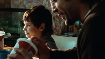 Movie still from “Biutiful” (2010), directed by Alejandro G. Iñárritu – A man and a boy sitting on a couch; Close Up shot, Over the shoulder angle