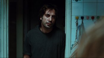 Movie still from “Biutiful” (2010), directed by Alejandro G. Iñárritu – A man standing next to a bathroom door; Medium shot, Over the shoulder angle