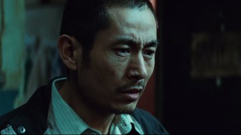 Movie still from “Biutiful” (2010), directed by Alejandro G. Iñárritu – A person wearing a suit and tie; Close Up shot, Low angle