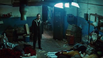 Movie still from “Biutiful” (2010), directed by Alejandro G. Iñárritu – A man standing in a room with a lot of clutter around him; Wide shot, High angle