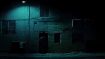 Movie still from “Biutiful” (2010), directed by Alejandro G. Iñárritu – A man standing in front of a building at night; Extreme Wide shot, Low angle