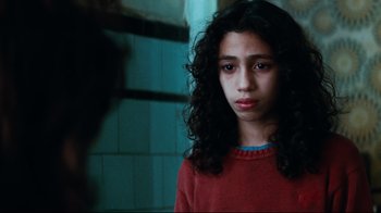 Movie still from “Biutiful” (2010), directed by Alejandro G. Iñárritu – A young girl with long black curly hair stares into the camera; Close Up shot, Low angle