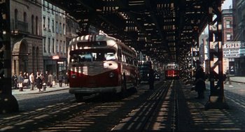 Movie still from “Black Caesar” (1973), directed by Larry Cohen – A red and white bus on a train track; Extreme Wide shot, Low angle