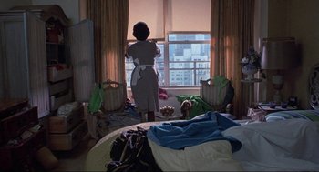 Movie still from “Black Caesar” (1973), directed by Larry Cohen – A woman standing in front of a window looking out at a city; Wide shot, Low angle