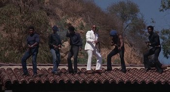 Movie still from “Black Caesar” (1973), directed by Larry Cohen – A group of men standing on top of a roof; Wide shot, Low angle
