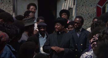 Movie still from “Black Caesar” (1973), directed by Larry Cohen – A group of men standing next to each other; Medium shot, Over the shoulder angle
