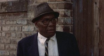 Movie still from “Black Caesar” (1973), directed by Larry Cohen – An older man wearing a suit and hat; Close Up shot, Low angle