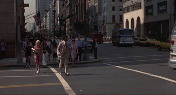 Movie still from “Black Caesar” (1973), directed by Larry Cohen – A group of people walking across a street; Extreme Wide shot, Over the shoulder angle