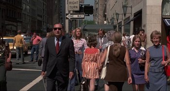 Movie still from “Black Caesar” (1973), directed by Larry Cohen – A group of people walking down a street; Wide shot, Low angle