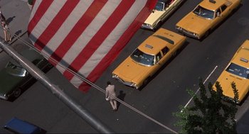 Movie still from “Black Caesar” (1973), directed by Larry Cohen – An aerial view of a man walking across the street; Extreme Wide shot, Overhead angle