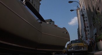 Movie still from “Black Caesar” (1973), directed by Larry Cohen – A car parked on the side of the road next to a street light; Wide shot, Low angle