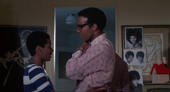 Movie still from “Black Caesar” (1973), directed by Larry Cohen – A man and a woman standing next to each other in a room; Medium shot, Low angle
