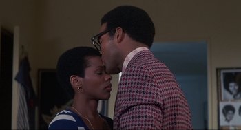 Movie still from “Black Caesar” (1973), directed by Larry Cohen – A man and a woman are kissing in a room; Close Up shot, Low angle