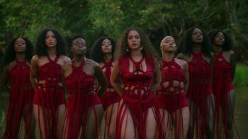 Movie still from “Black Is King” (2020), directed by Julian Klincewicz – A group of women standing next to each other in red outfits; Extreme Wide shot, Low angle