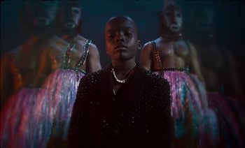 Movie still from “Black Is King” (2020), directed by Julian Klincewicz – A man standing in front of a group of women; Close Up shot, Low angle