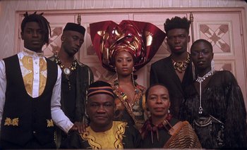 Movie still from “Black Is King” (2020), directed by Julian Klincewicz – A group of men and women posing for a picture; Medium shot, Low angle