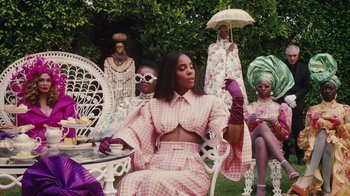 Movie still from “Black Is King” (2020), directed by Julian Klincewicz – A group of people sitting around a table; Medium shot, Over the shoulder angle