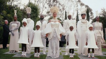 Movie still from “Black Is King” (2020), directed by Julian Klincewicz – A group of people dressed in white standing next to each other; Wide shot, Low angle