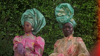 Movie still from “Black Is King” (2020), directed by Julian Klincewicz – A couple of women standing next to each other; Medium shot, Low angle