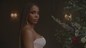 Movie still from “Black Is King” (2020), directed by Julian Klincewicz – A woman in a strapless white dress with long braids; Close Up shot, Low angle