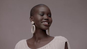 Movie still from “Black Is King” (2020), directed by Julian Klincewicz – A woman with short black hair wearing large earrings; Close Up shot, Low angle