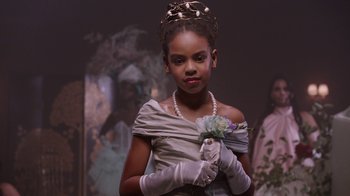 Movie still from “Black Is King” (2020), directed by Julian Klincewicz – A young girl wearing a dress and a crown; Close Up shot, Over the shoulder angle