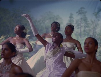 Movie still from “Black Is King” (2020), directed by Julian Klincewicz – A group of young women in white dresses and white gloves; Medium shot, Low angle