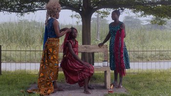 Movie still from “Black Is King” (2020), directed by Julian Klincewicz – A group of women standing next to each other on a bench; Medium shot, High angle