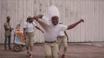 Movie still from “Black Is King” (2020), directed by Julian Klincewicz – A group of men in white shirts and hats; Medium shot, Low angle