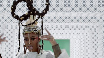 Movie still from “Black Is King” (2020), directed by Julian Klincewicz – A woman in a white dress with a black and white headdress; Close Up shot, Low angle