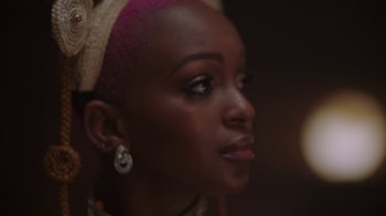 Movie still from “Black Is King” (2020), directed by Julian Klincewicz – A person wearing a headscarf; Close Up shot, Over the shoulder angle