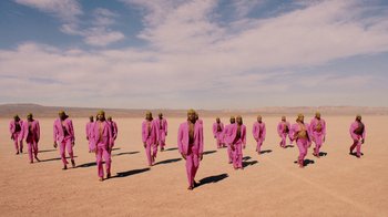 Movie still from “Black Is King” (2020), directed by Julian Klincewicz – A group of people standing in the desert; Extreme Wide shot, High angle