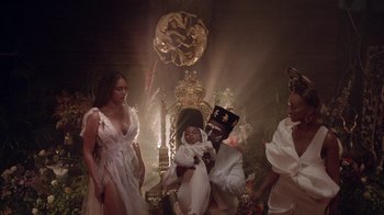 Movie still from “Black Is King” (2020), directed by Julian Klincewicz – A group of people standing in a room; Medium shot, High angle