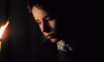Movie still from “Black Jack” (1979), directed by Ken Loach – A young boy in the dark with his head turned to the side; Close Up shot, High angle