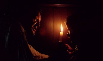 Movie still from “Black Jack” (1979), directed by Ken Loach – A man and a woman looking at a candle in a dark room; Medium shot, Low angle