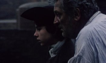 Movie still from “Black Jack” (1979), directed by Ken Loach – A man and a woman standing next to each other; Medium shot, Over the shoulder angle