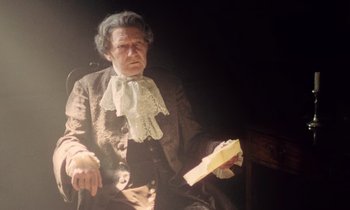 Movie still from “Black Jack” (1979), directed by Ken Loach – An old man sitting in a chair holding a piece of paper; Medium shot, Low angle