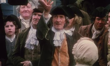Movie still from “Black Jack” (1979), directed by Ken Loach – An old man wearing a hat and holding his hands up; Medium shot, High angle