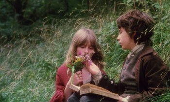 Movie still from “Black Jack” (1979), directed by Ken Loach – A boy and a girl sitting in the grass; Medium shot, Over the shoulder angle