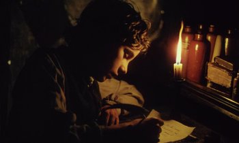 Movie still from “Black Jack” (1979), directed by Ken Loach – A young boy is writing in a notebook; Close Up shot, High angle