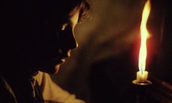 Movie still from “Black Jack” (1979), directed by Ken Loach – A woman is looking at a candle in the dark; Close Up shot, Over the shoulder angle