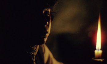 Movie still from “Black Jack” (1979), directed by Ken Loach – A person with a dark background looking into the distance; Close Up shot, Over the shoulder angle